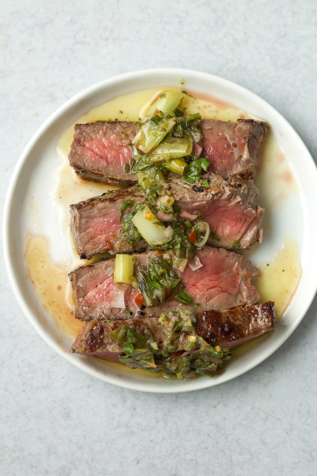 Grilled scallion chimichurri sauce on thinly sliced steak.