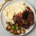 Finished plate with boneless short ribs, mashed potatoes and roasted vegetable.