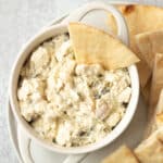 Spicy feta dip in bowl with pita.