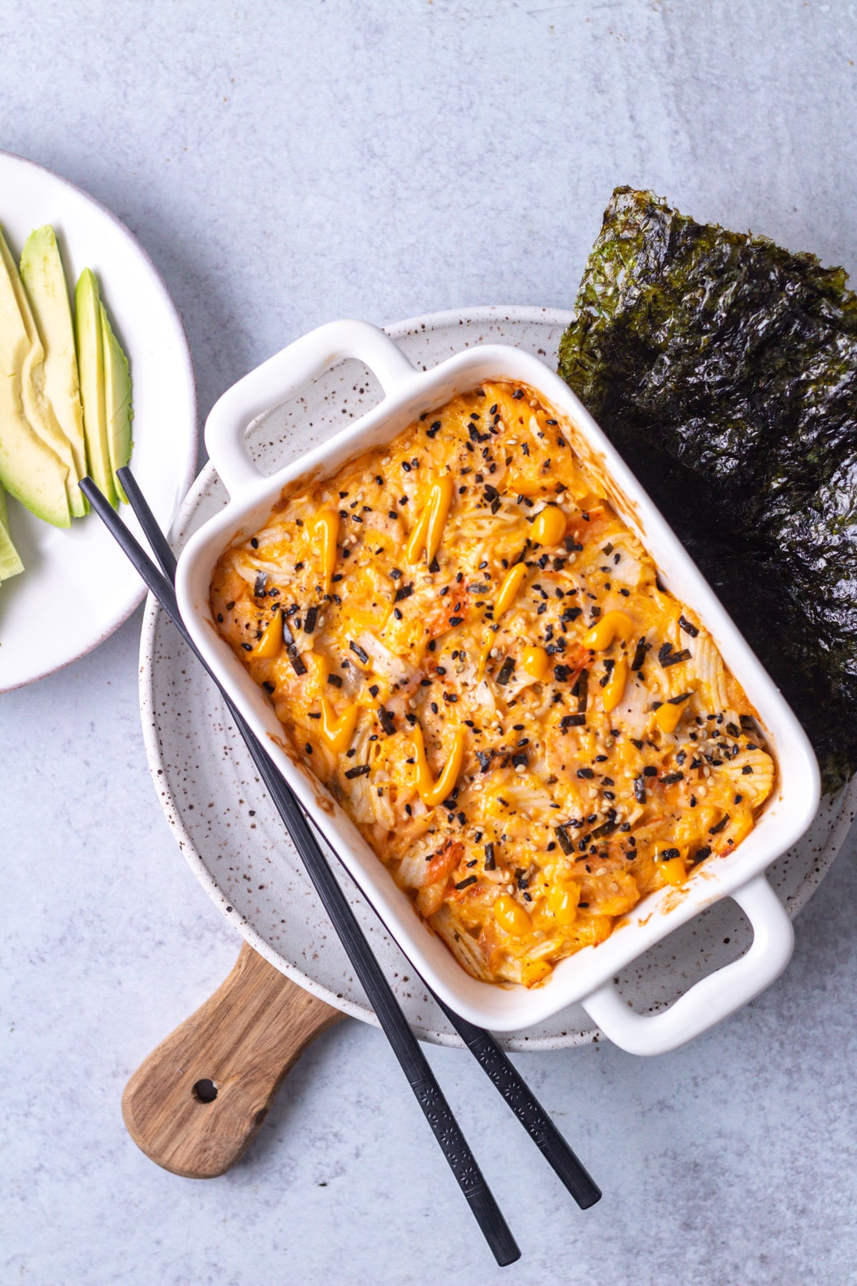 Sushi bake dish on plate with chopsticks.