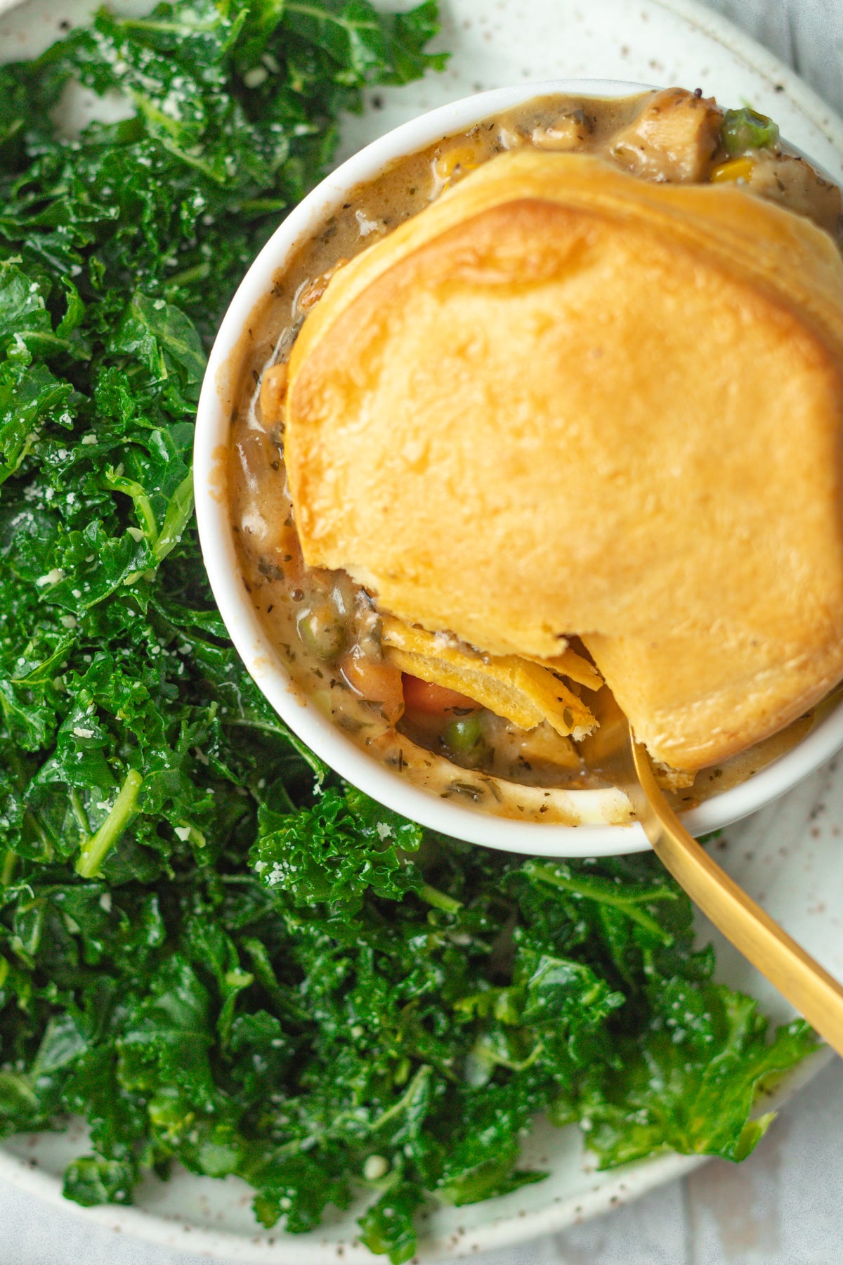 Chicken pot pie on plate with kale salad.