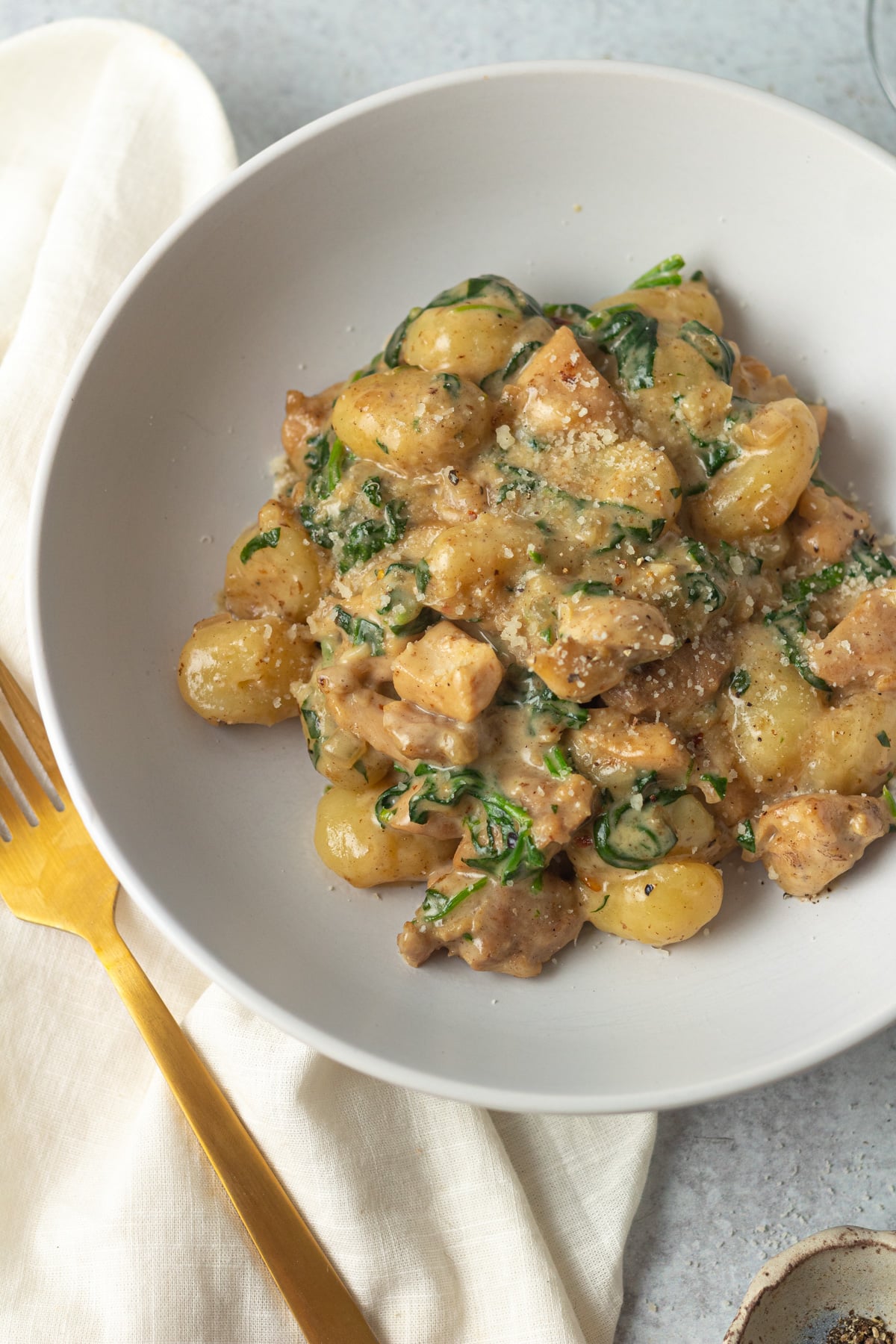 Bowl of one pan creamy chicken and gnocchi on table.