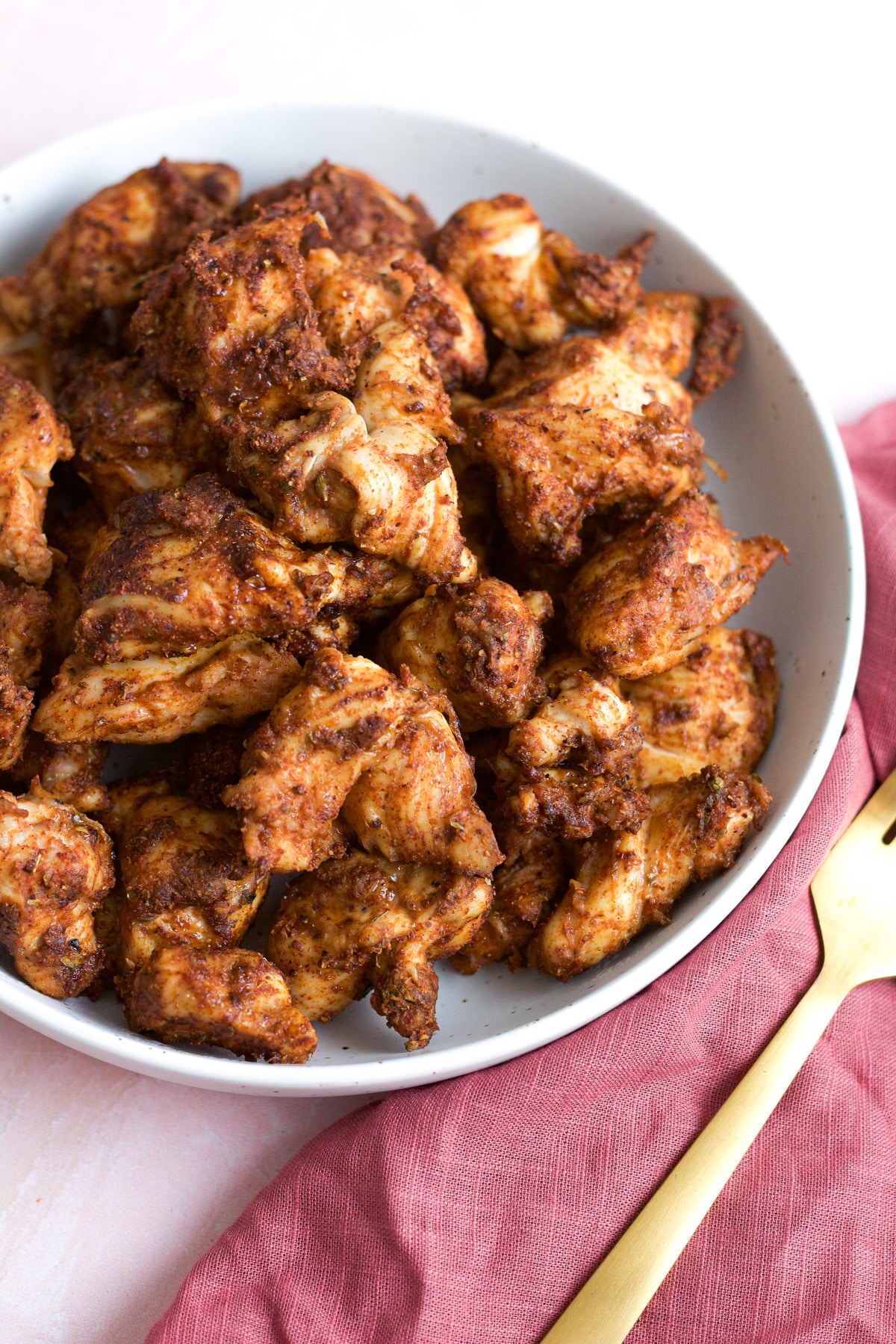 Chicken bites piled on white plate.