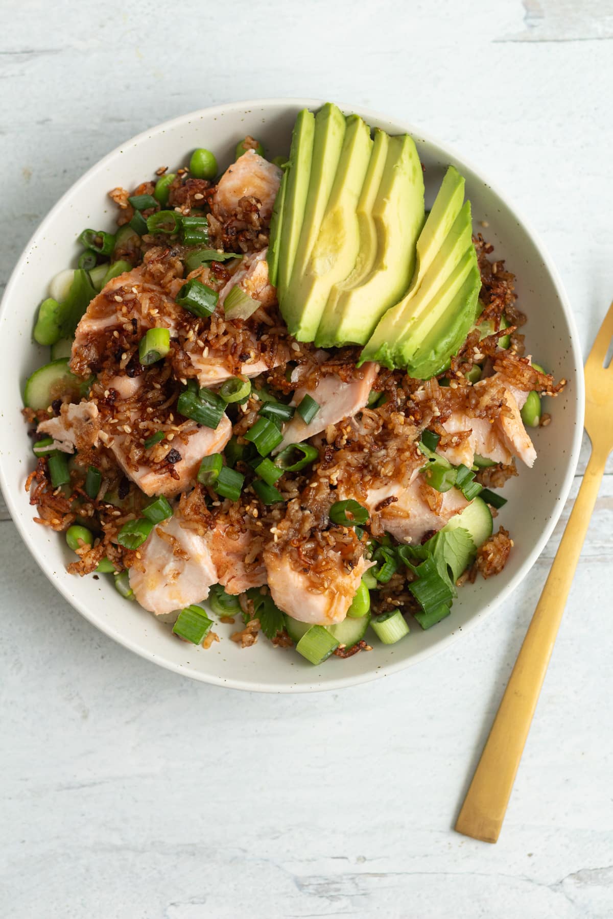 Crispy rice salmon cucumber salad in bowl.