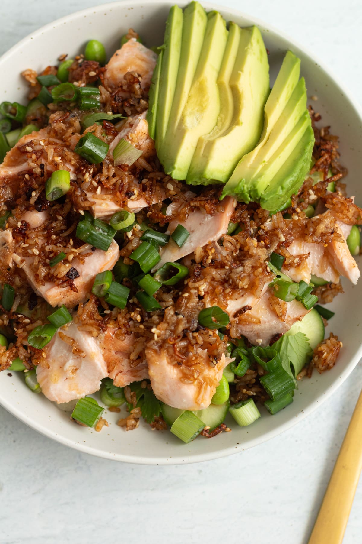 Close shot of crispy rice salmon salad in bowl with fork.