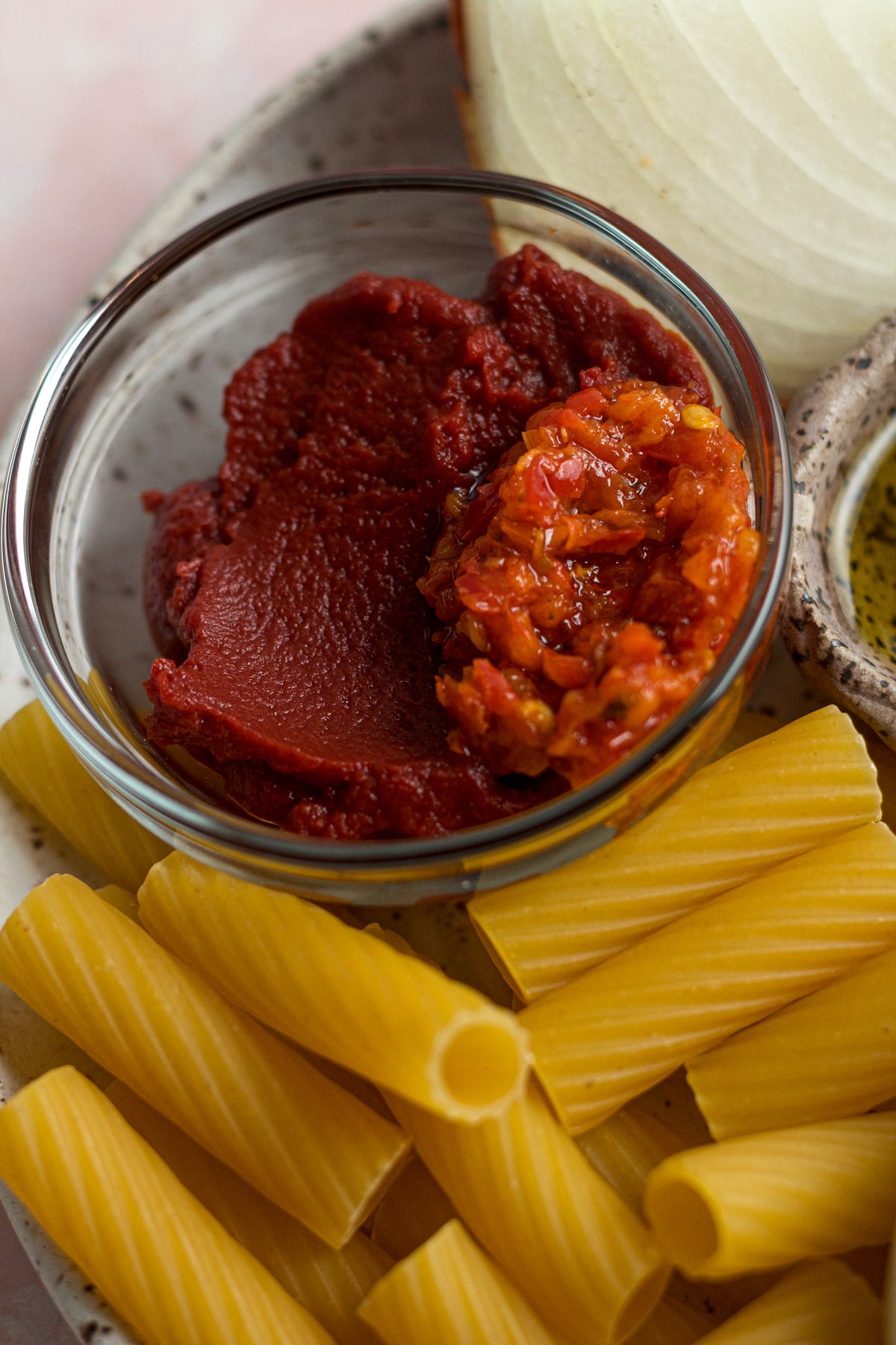 Close shot of tomato paste and chili paste in glass bowl.