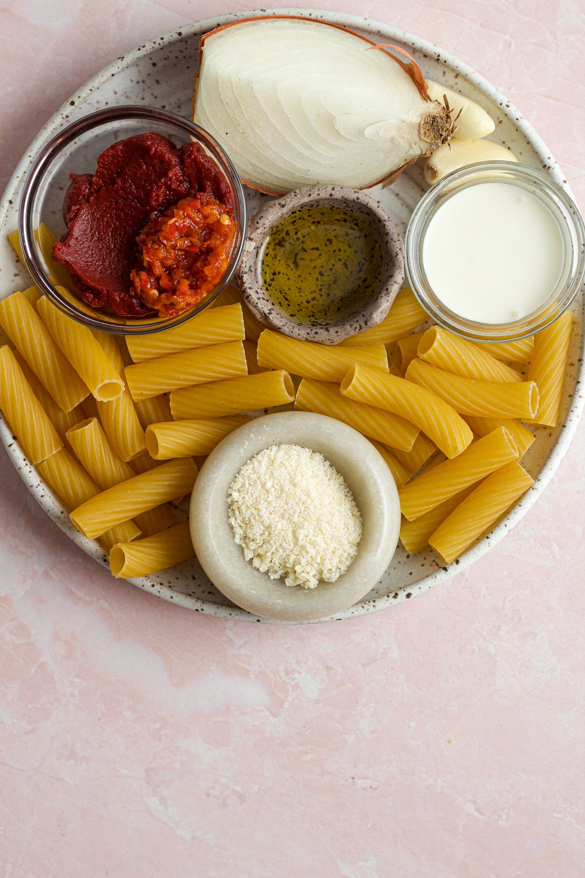 plate with pasta alla vodka ingredients on a board.